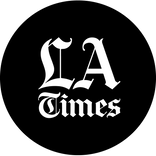 black circle with white letters spelling out la times